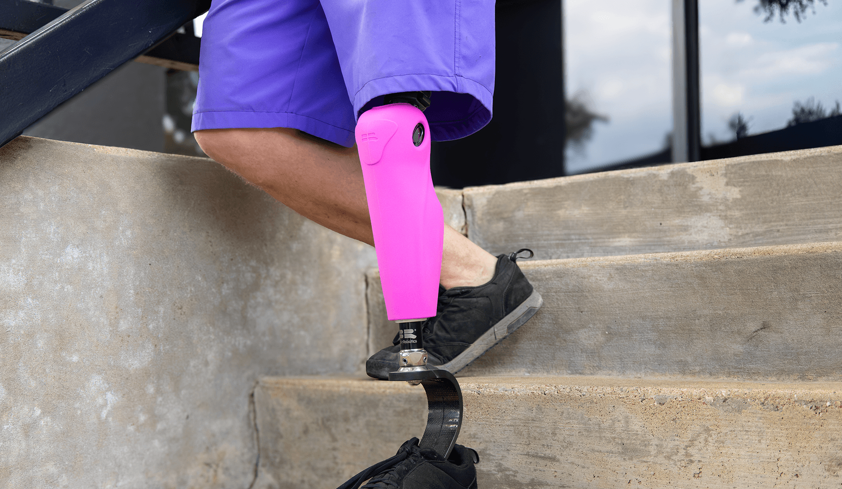 A Kneuro user climbing stairs wearing a pink Kneuro Cover
